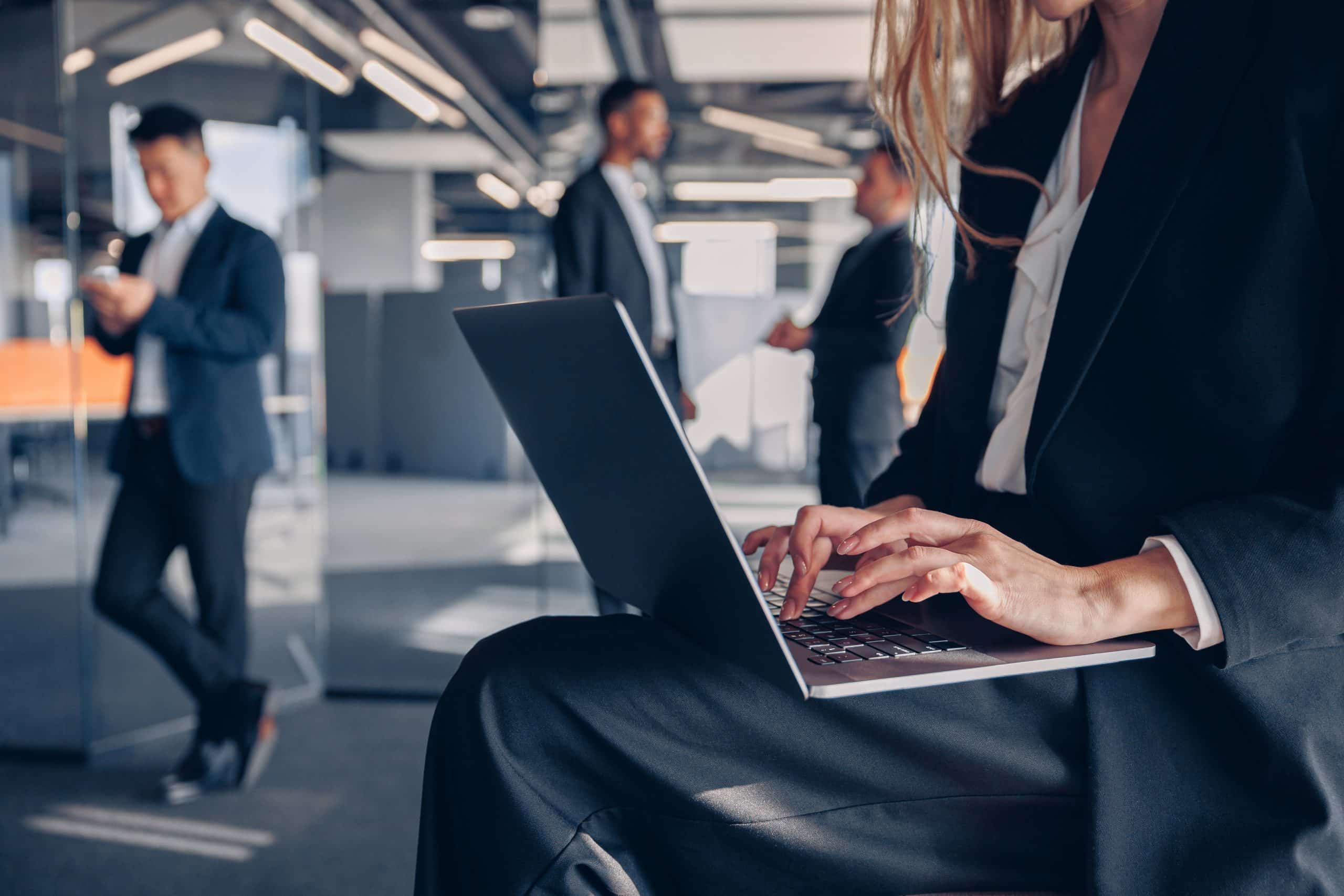 Close up of unrecognisable businesswoman working on laptop in office Close up of unrecognisable businesswoman working on laptop in office on colleagues background